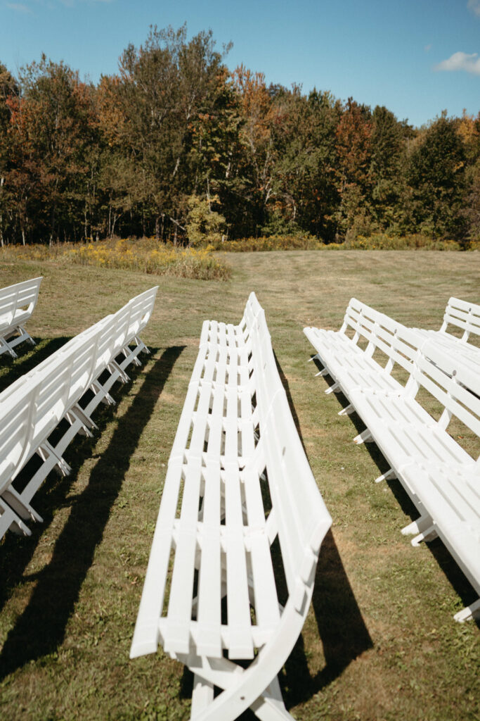 Rows of white benches on a grassy ceremony lawn