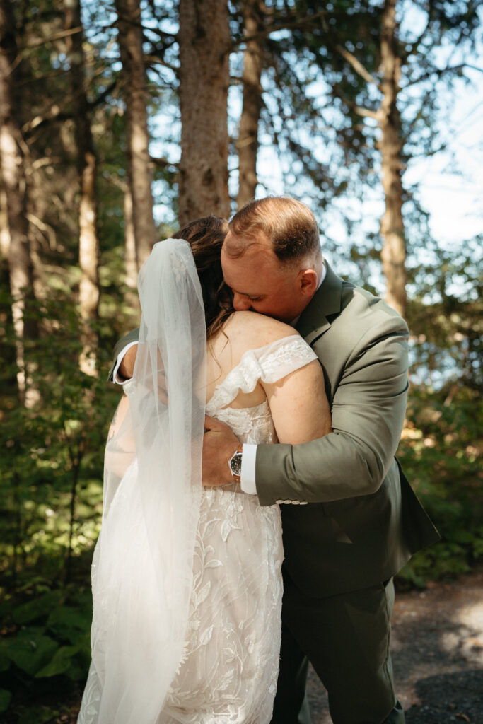 Couple embracing in a forest, one in a green suit