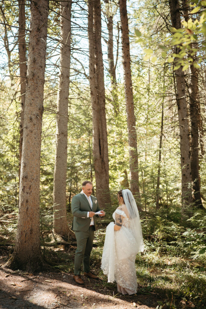 Couple reading notes to each other among tall pines