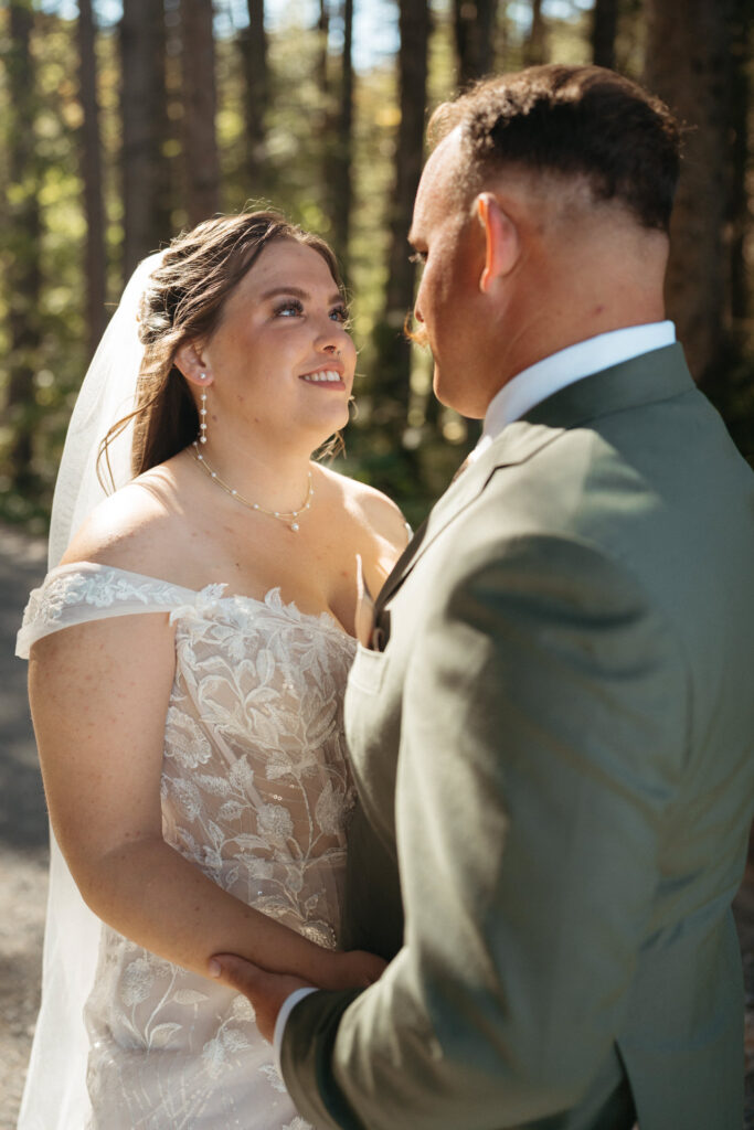 Close-up of a couple gazing at each other, holding hands, one in a green suit