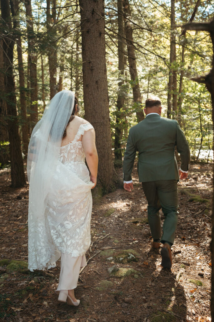 Person in a veil and person in a green suit walking through the woods