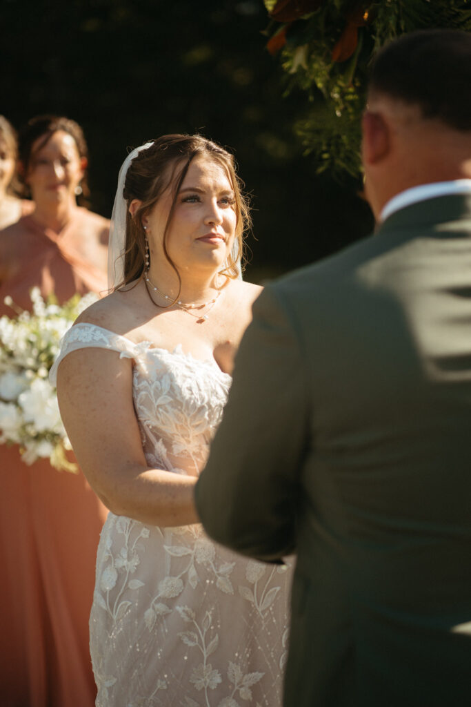 Close-up of a person in a lace gown looking at their partner during the ceremony