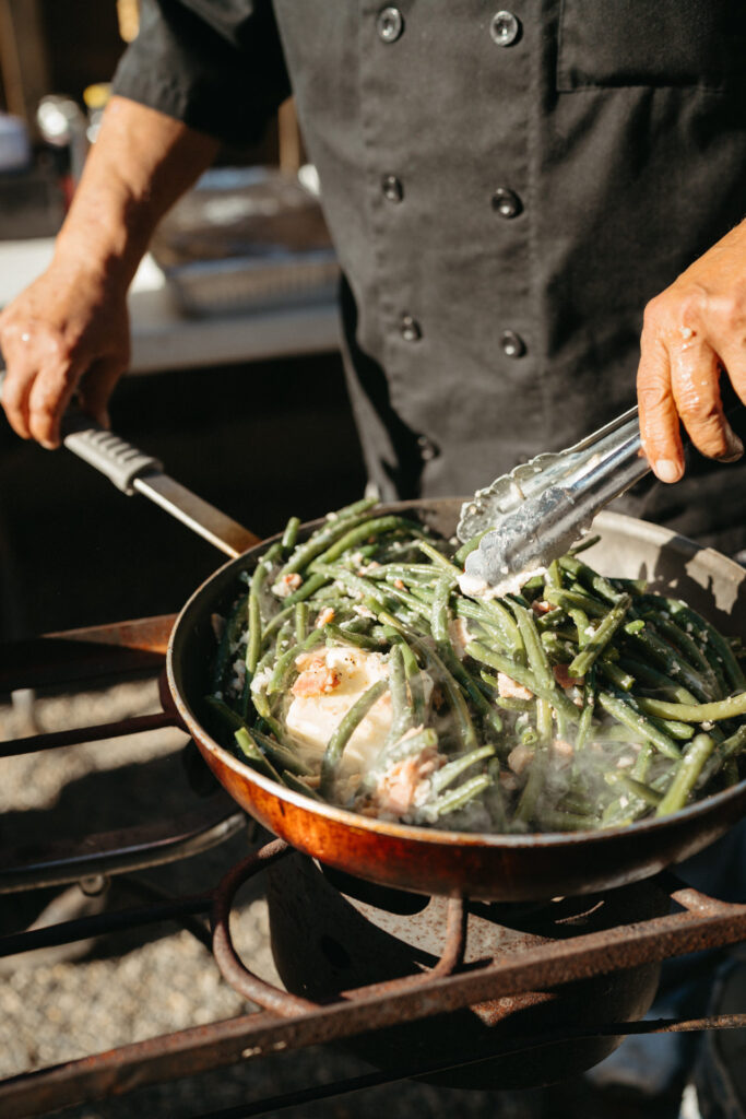Chef tossing green beans in a skillet