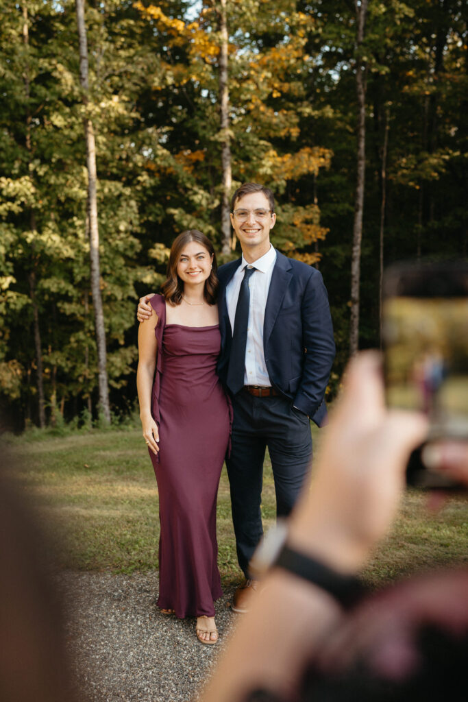 Two guests posing together while another person takes a photo