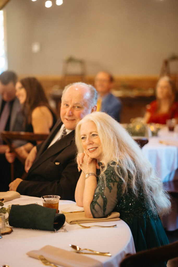 Two guests smiling at a table during the toasts
