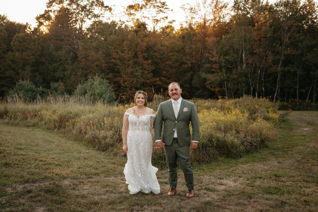 Couple standing on a grassy path through a meadow