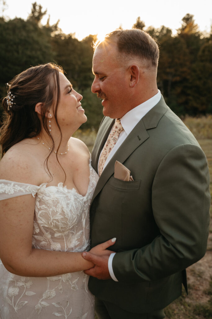 Couple embracing and smiling at each other in a field