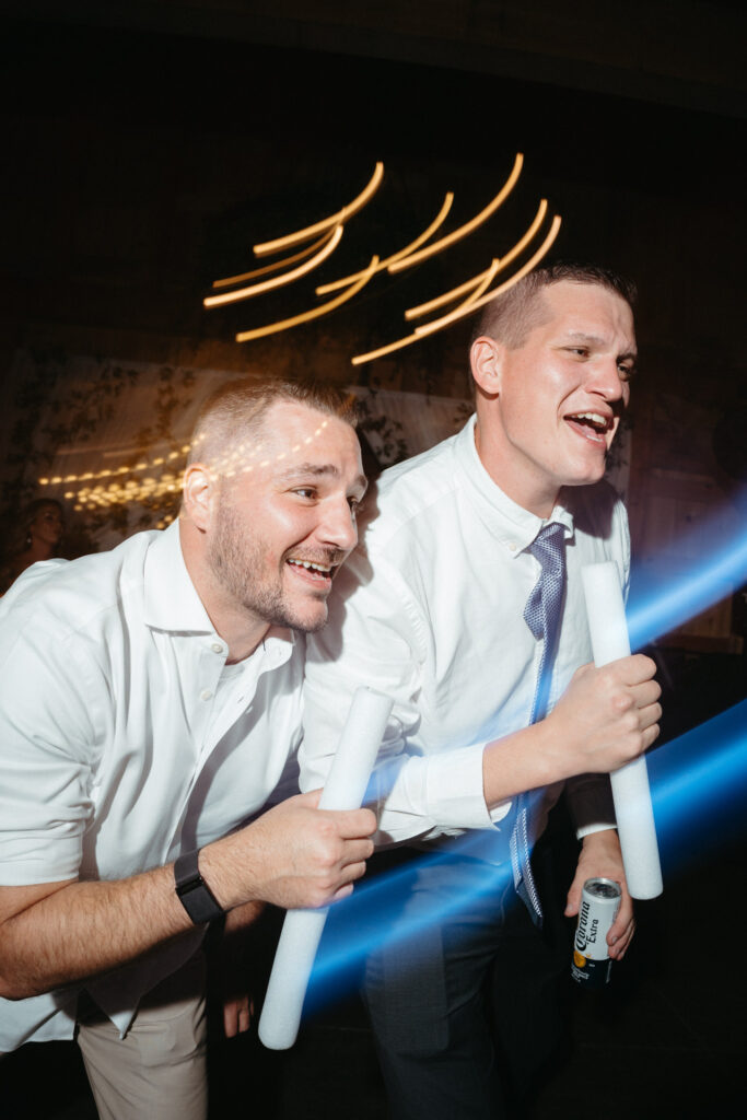 Two guests laughing on the dance floor with glow sticks