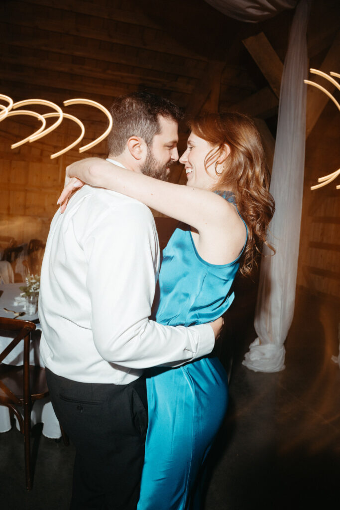 Two guests dancing close together at the reception