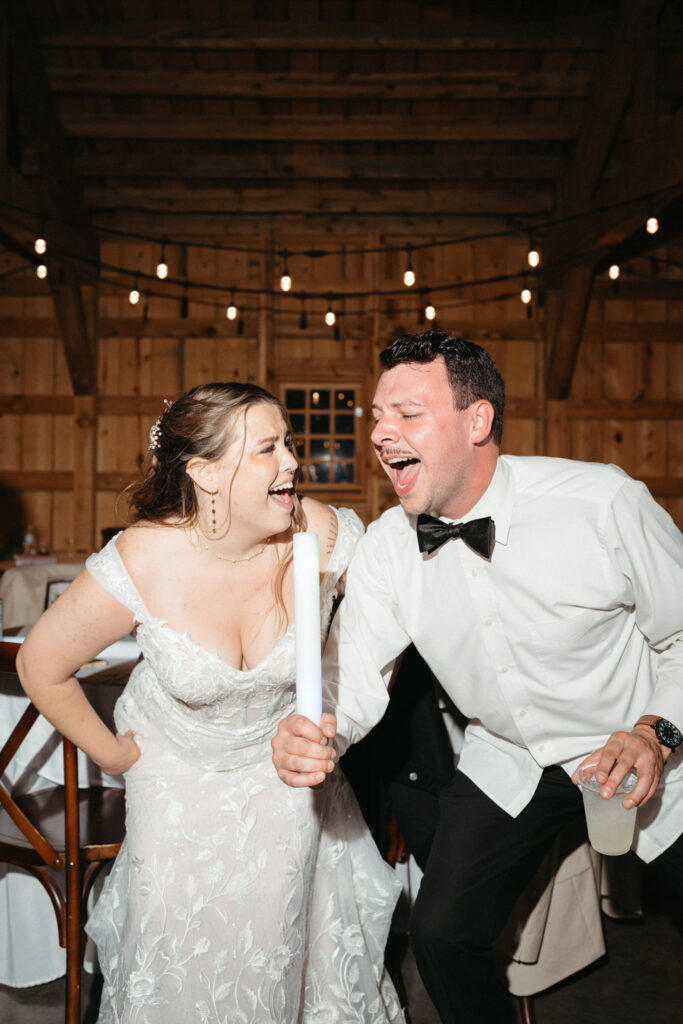 Couple laughing in the barn, one holding a glow stick