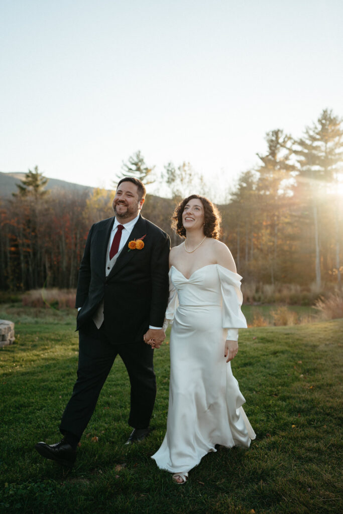 Couple smiling and walking across the lawn in golden light