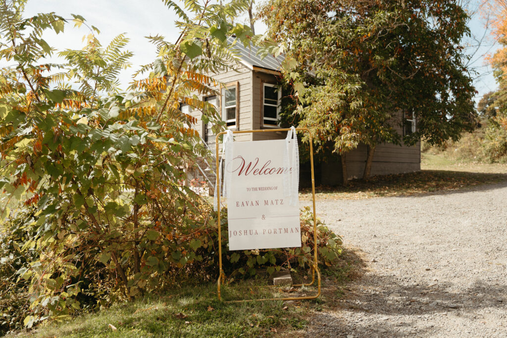 Welcome sign on an easel beside a gravel drive