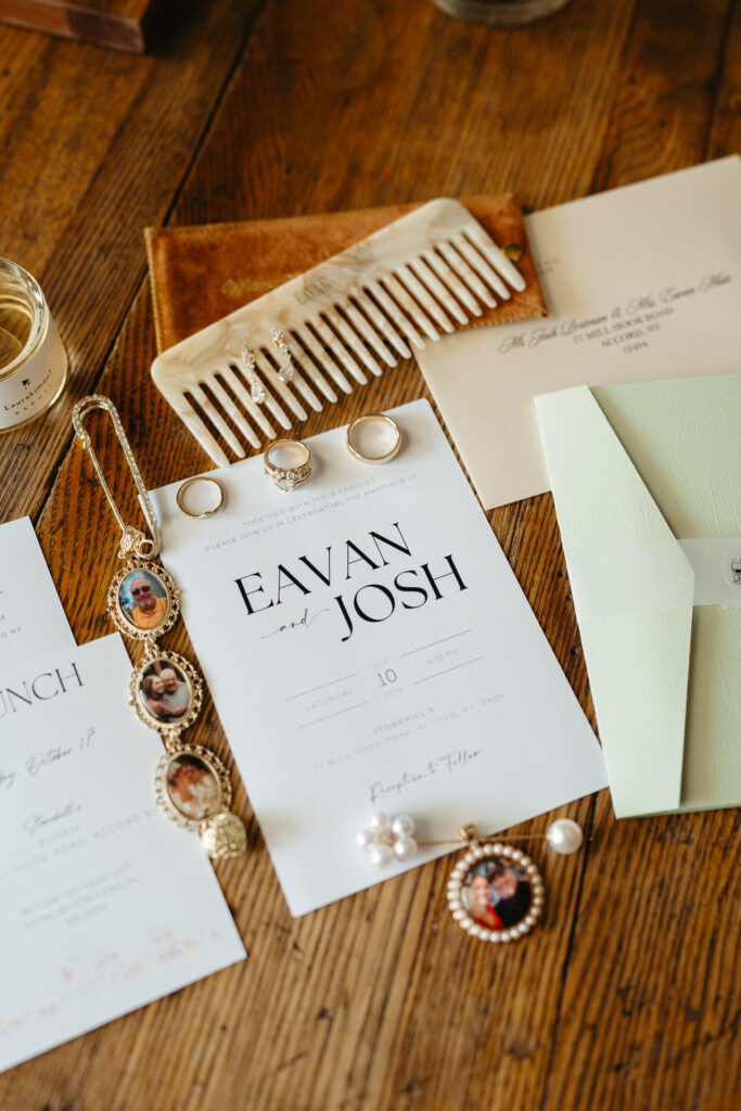 Invitation reading Eavan and Josh, with jewelry and a comb on a wooden table