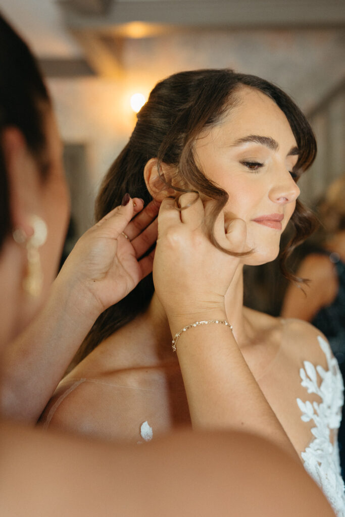 Person having an earring fastened by a helping hand