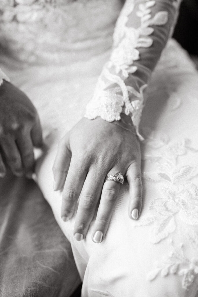 Black and white close-up of a ring and a lace sleeve