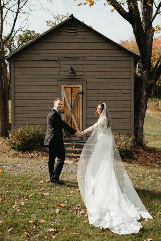 Couple holding hands outside a small gray cabin