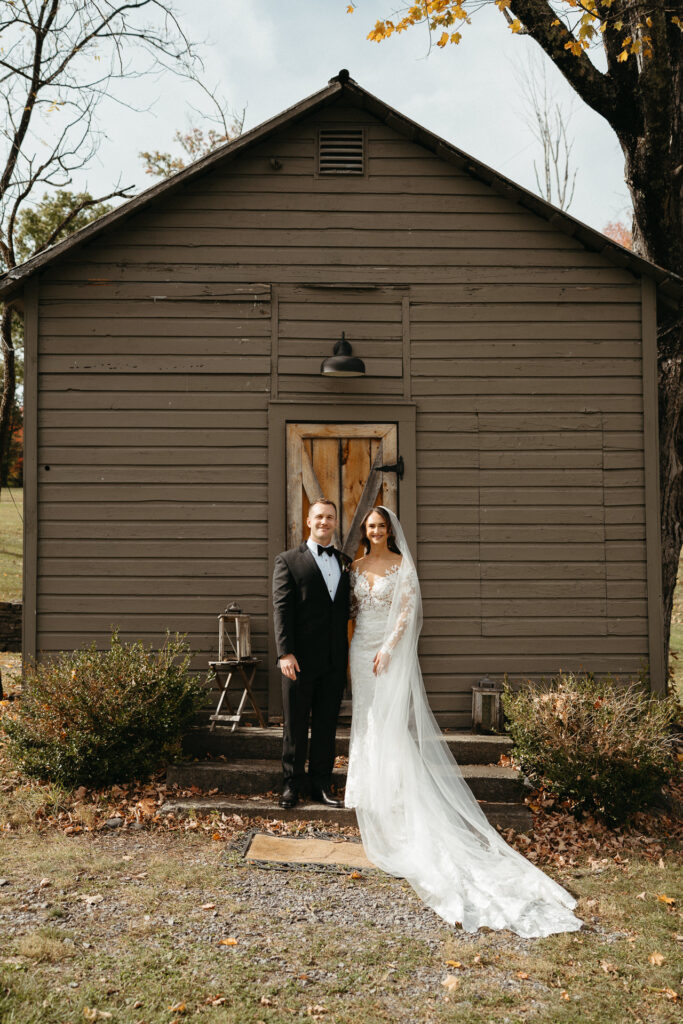Couple standing in front of a small gray cabin