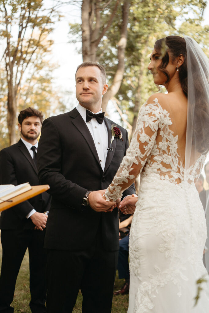 Couple holding hands with the officiant beside them