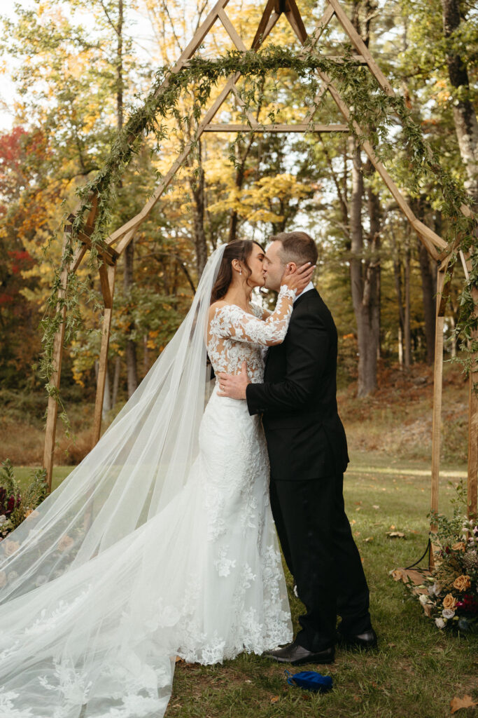 Couple kissing under the wooden arch