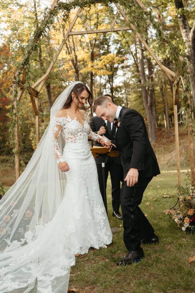 Couple laughing under the arch, one bending forward
