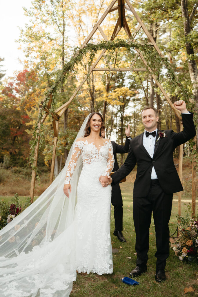 Couple under the arch, one with a fist raised in celebration