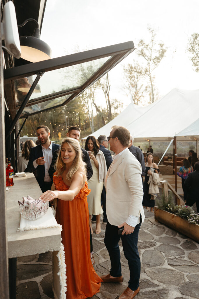 Bar window beside a patio where guests gather in the stone courtyard