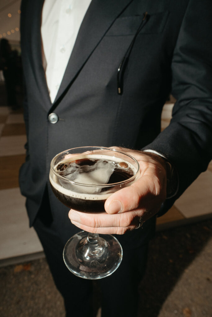 Guest holding an espresso martini in a coupe glass