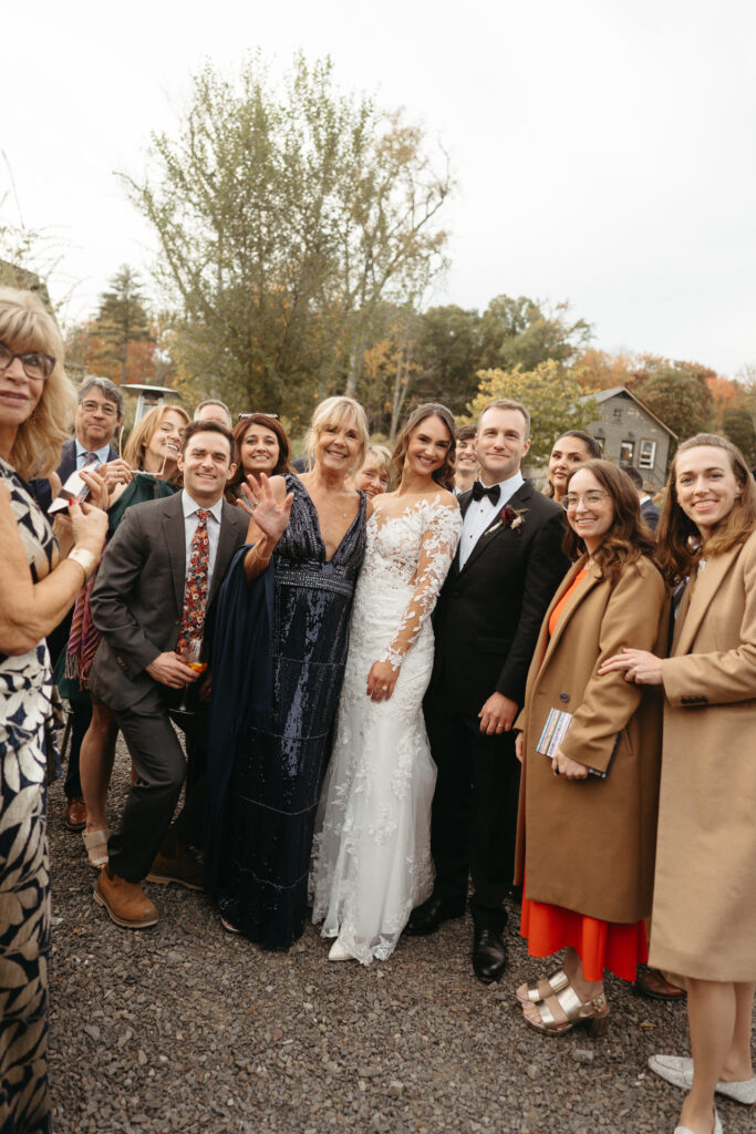 Couple posing with a group of guests outside the barn