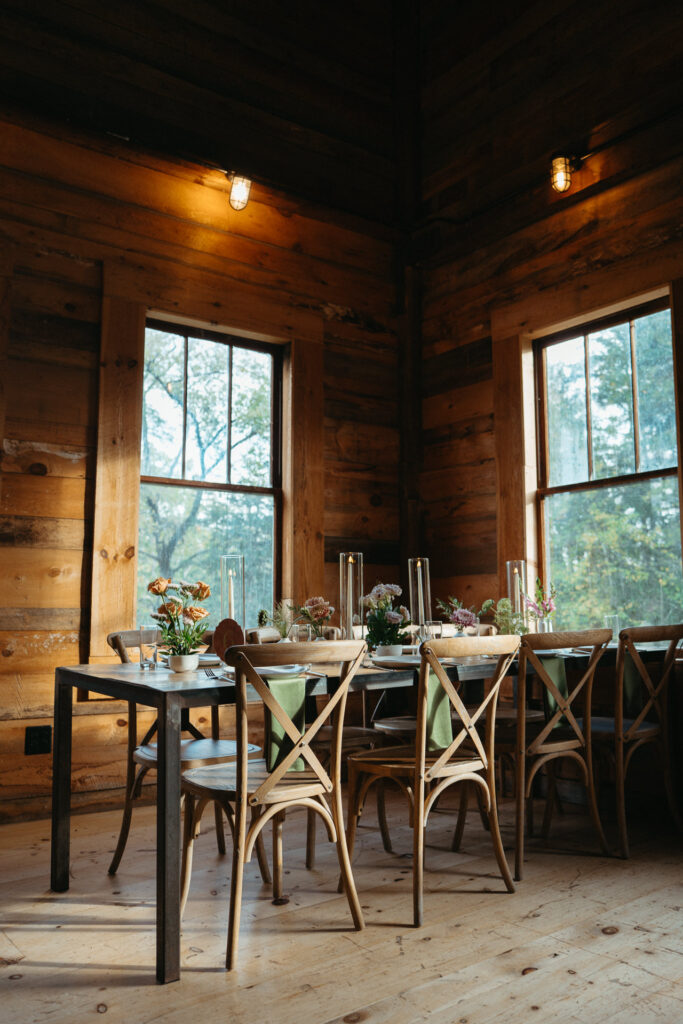 Barn dining room with tables set beside tall windows
