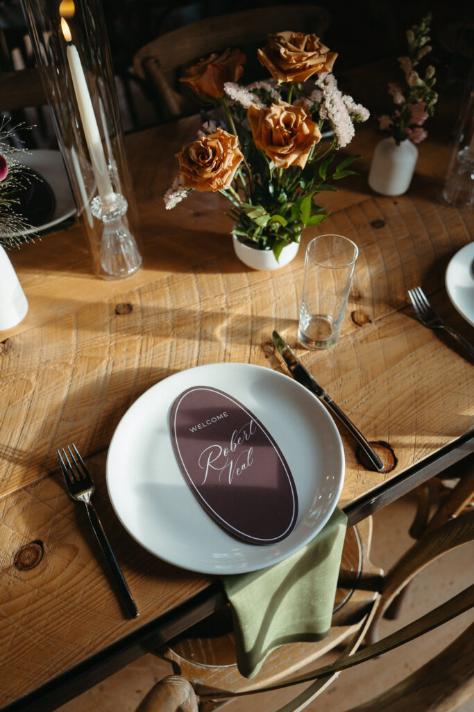 Close-up of a plate and place card with orange flowers