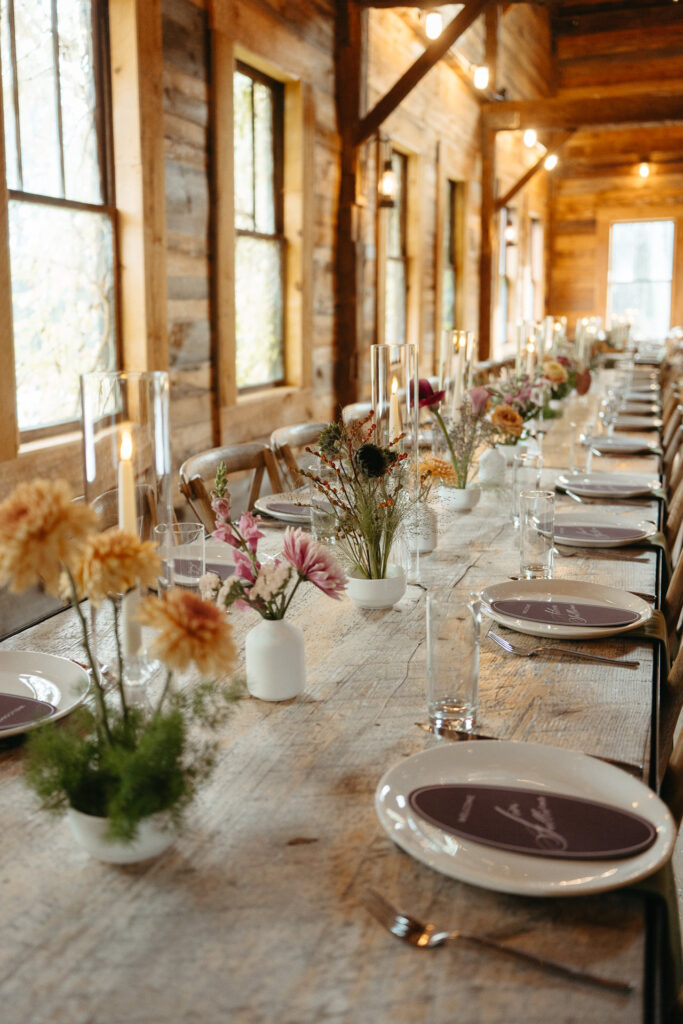 Long barn table set with flowers and place cards