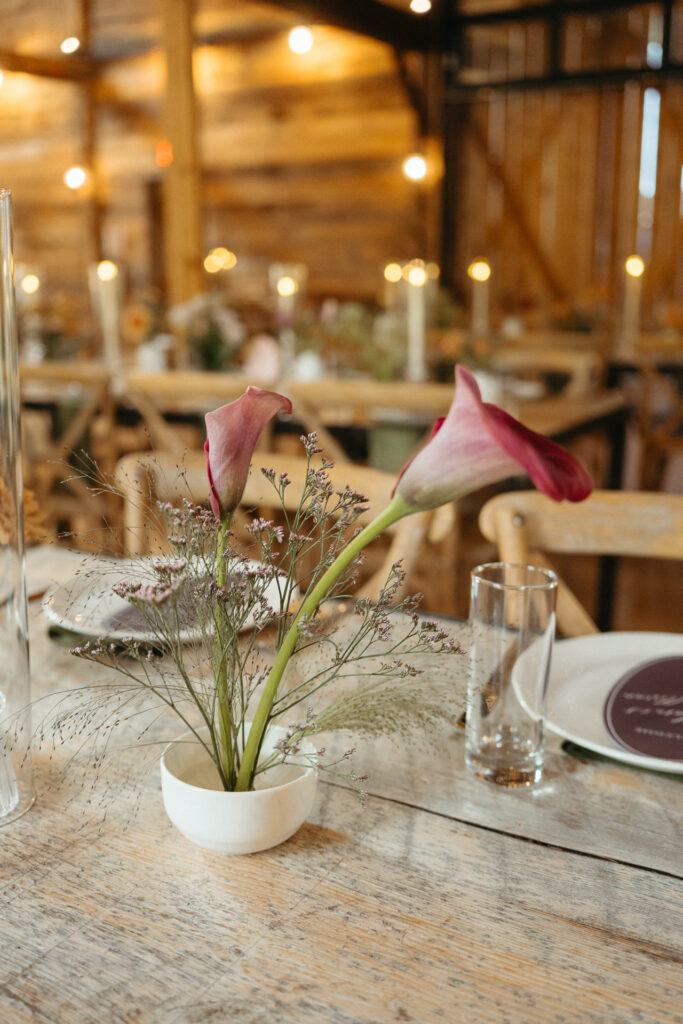 Calla lily in a small vase on a barn table
