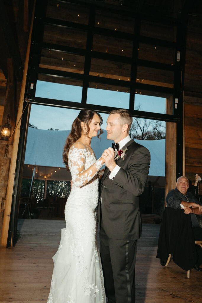 Couple dancing and smiling at each other in the barn