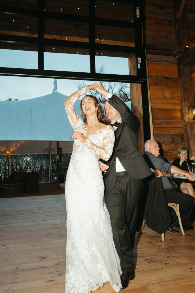Person spinning with arms overhead beside their partner on the dance floor
