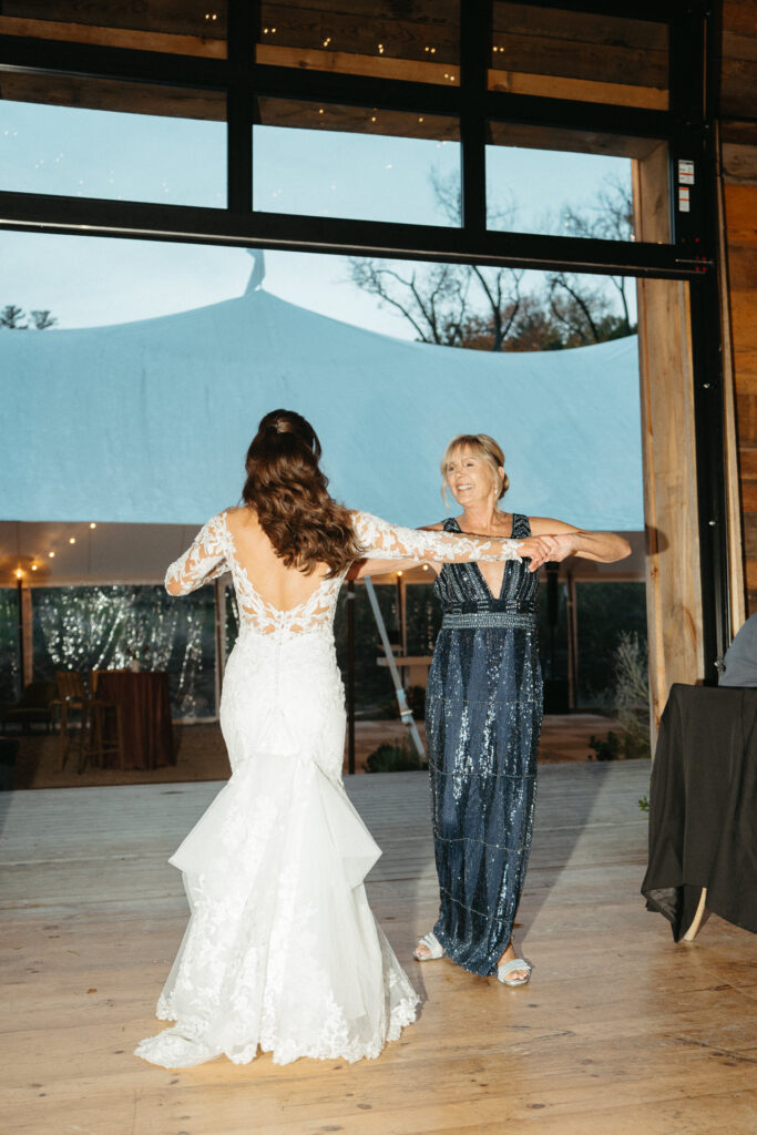 Person in a gown dancing with a guest in a beaded blue dress