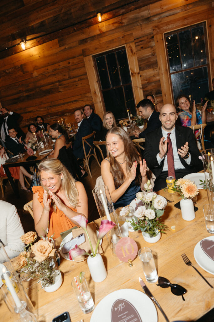 Guests laughing and applauding at a table