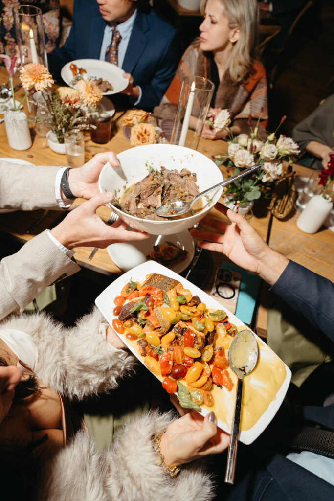 Hands passing platters of food around a table