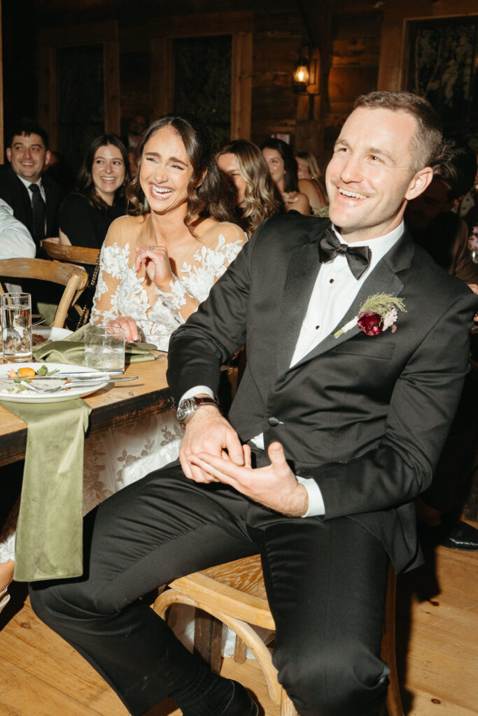 Couple smiling at their table during the toasts