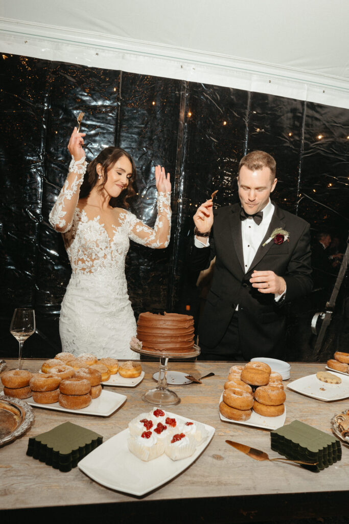 Couple laughing beside the cake, one dancing