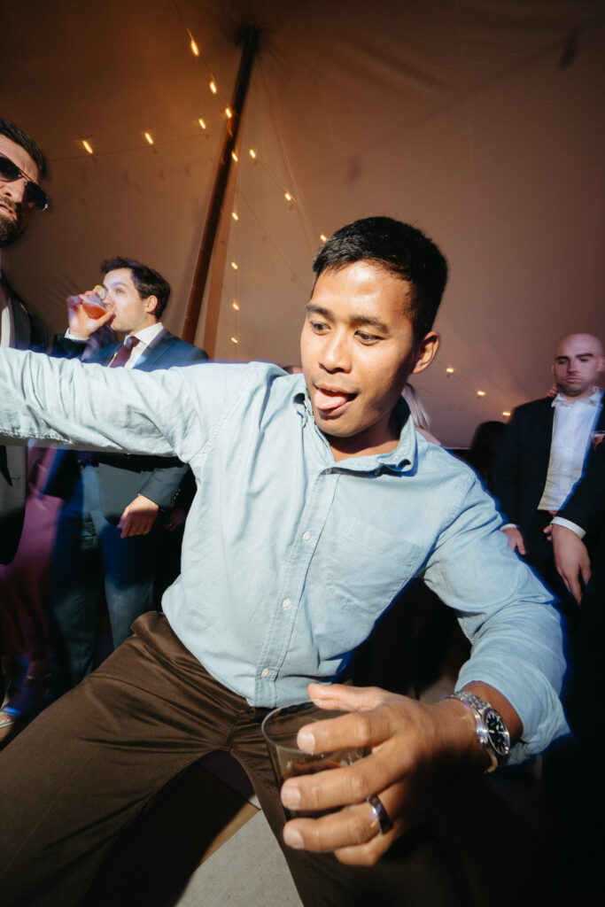 Guest in a light blue shirt dancing and sticking out their tongue