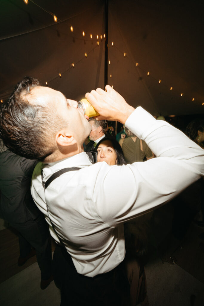 Guest in suspenders drinking from a can