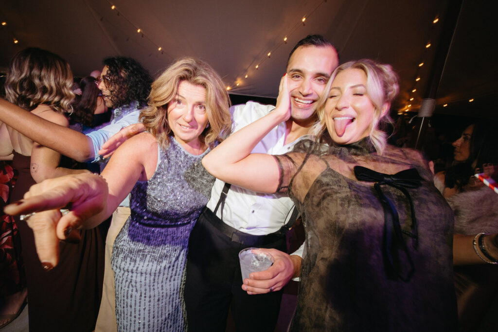 Guests dancing together, one sticking out their tongue