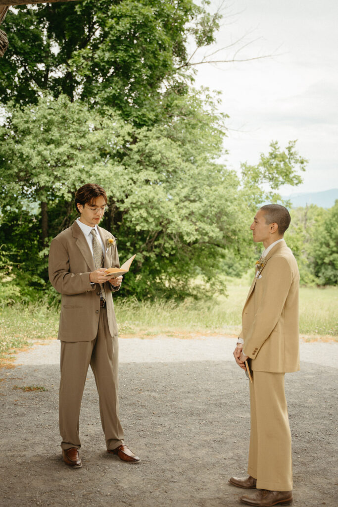 Couple facing each other during the vows in front of the trees