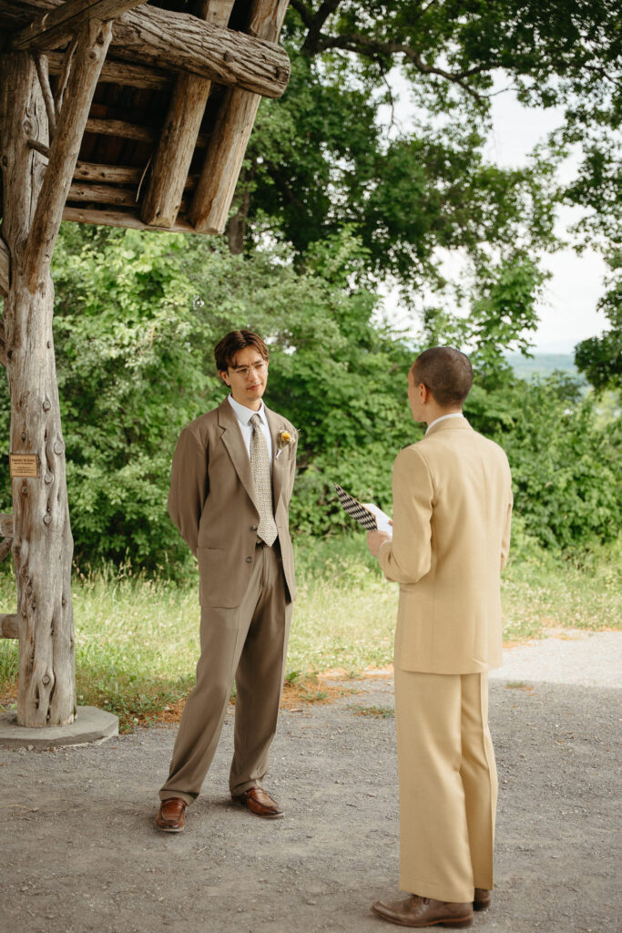 Couple standing apart under the gazebo, one holding a notebook