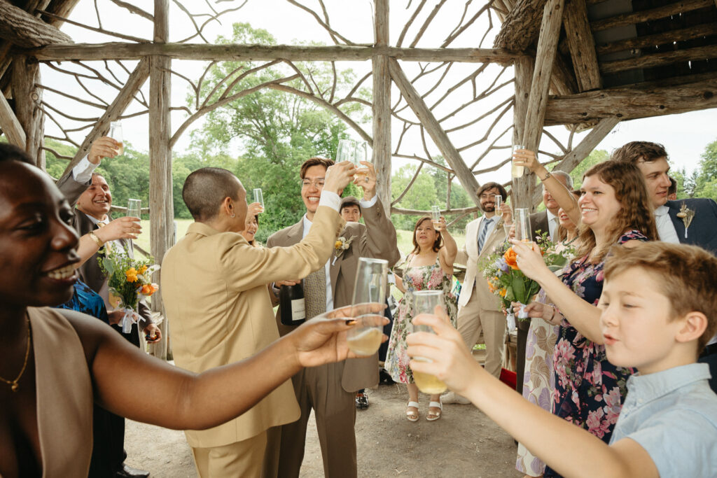 Guests raising glasses in a toast under the gazebo