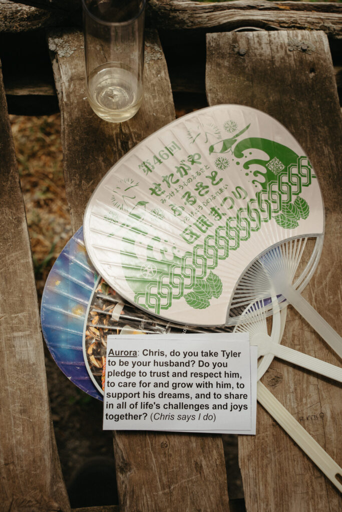 Paper fan and a printed ceremony script on a wooden bench