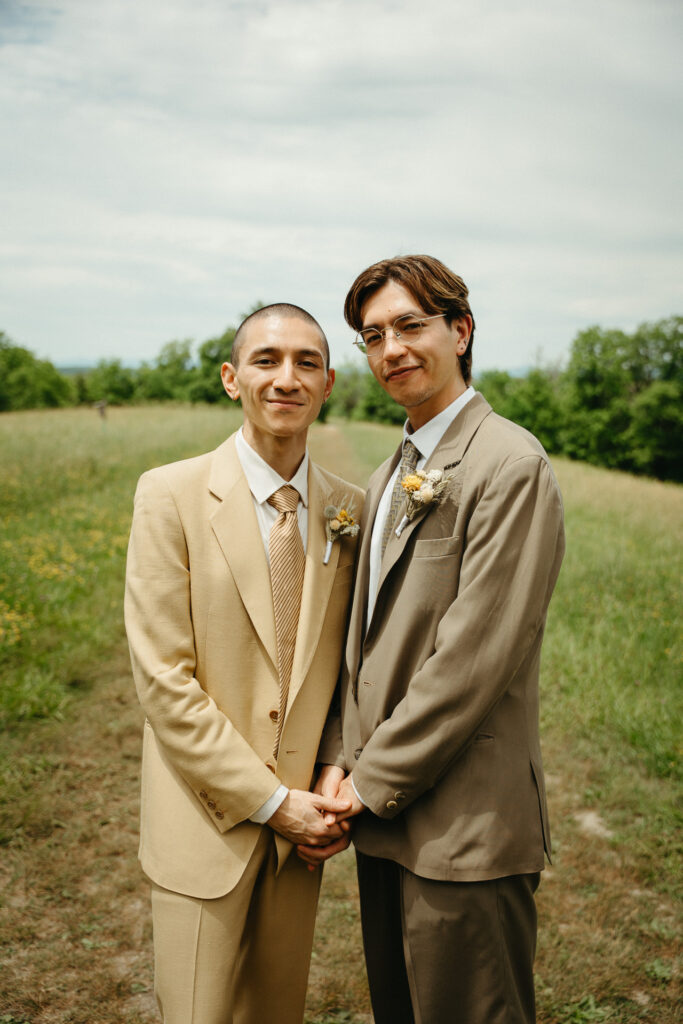 Couple standing close and holding hands in the meadow, looking away