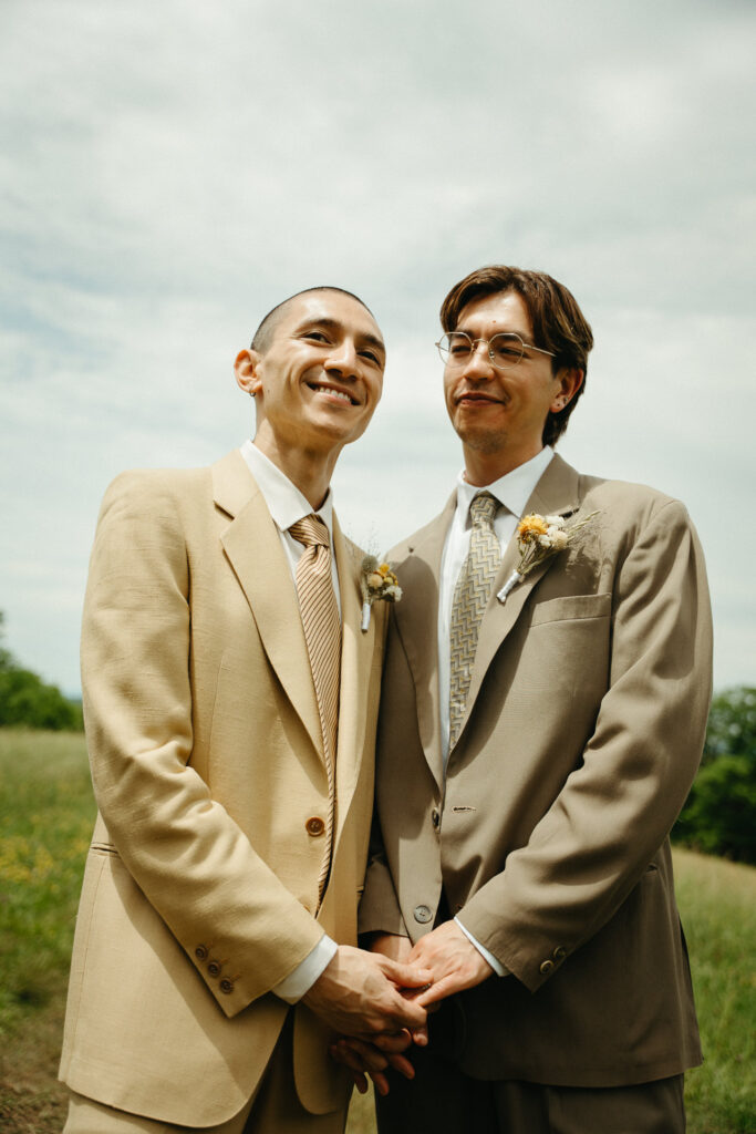 Couple smiling and holding hands in the meadow