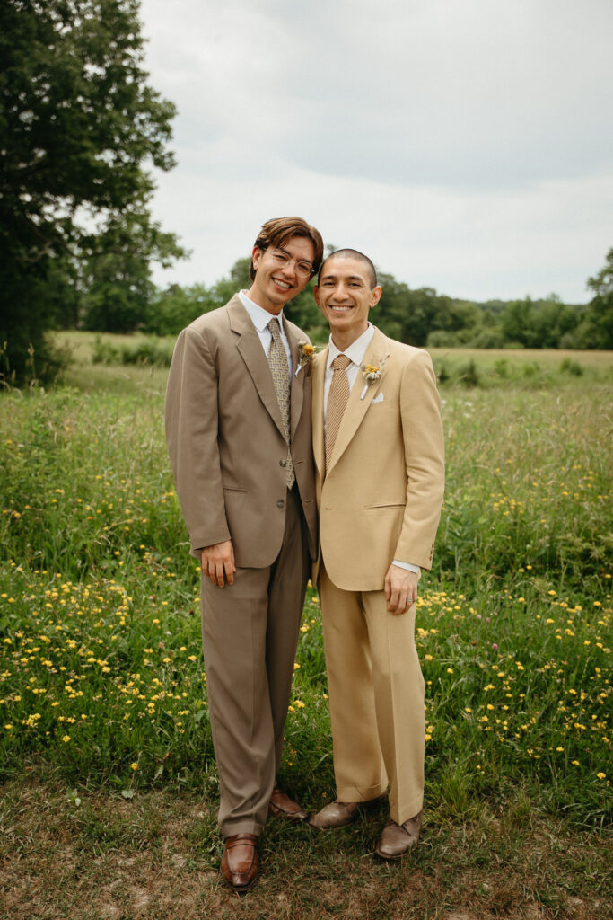 Couple standing side by side in a meadow with yellow wildflowers
