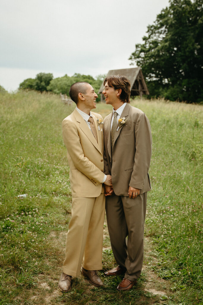 Couple touching foreheads in the meadow with the gazebo in the distance